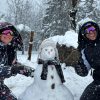 Pareja junto a muñeco de nieve