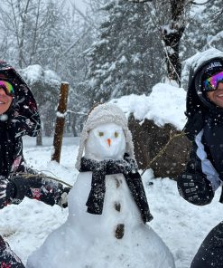 Pareja junto a muñeco de nieve