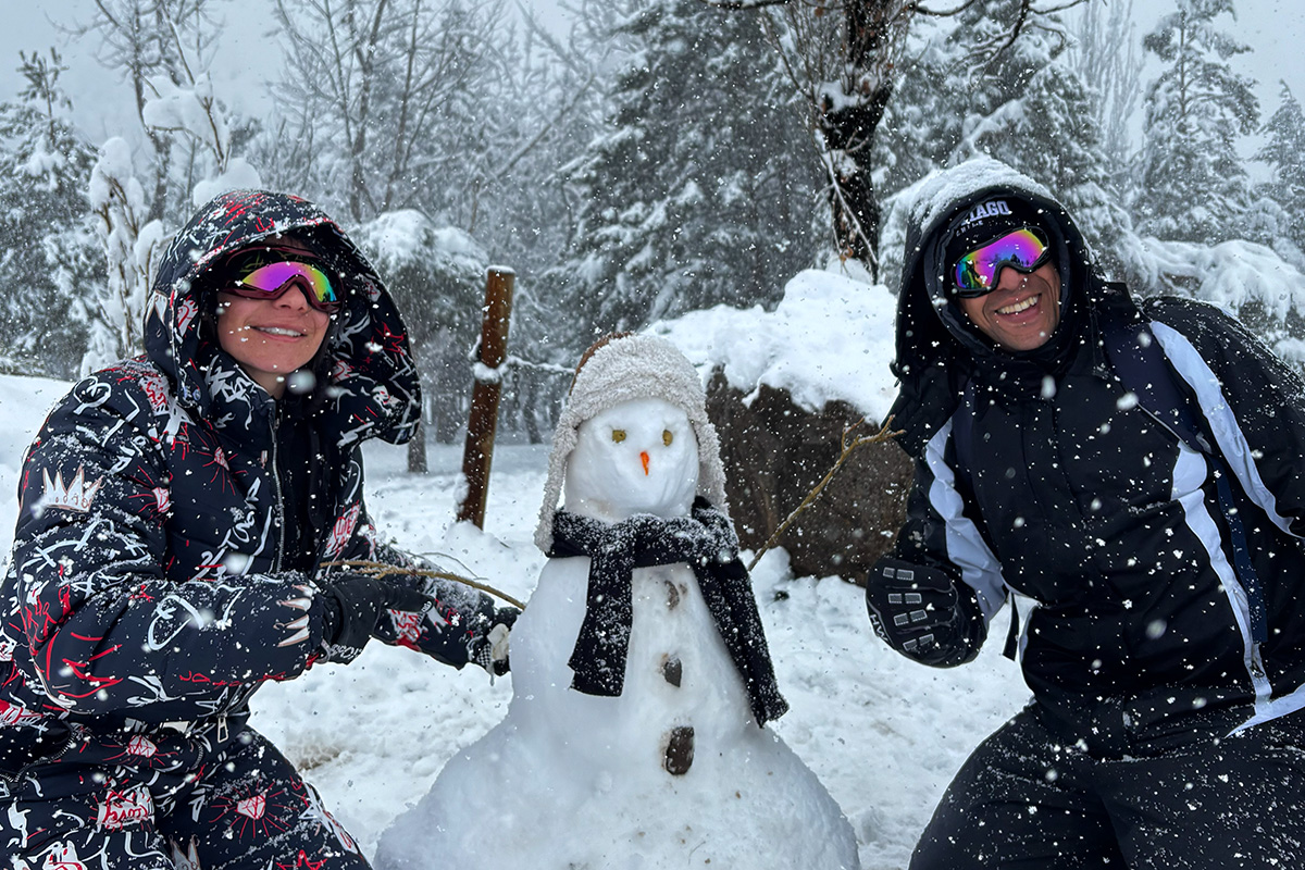 Pareja junto a muñeco de nieve