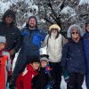 Grupo familiar en la nieve con bosque nevado de fondo