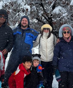 Grupo familiar en la nieve con bosque nevado de fondo