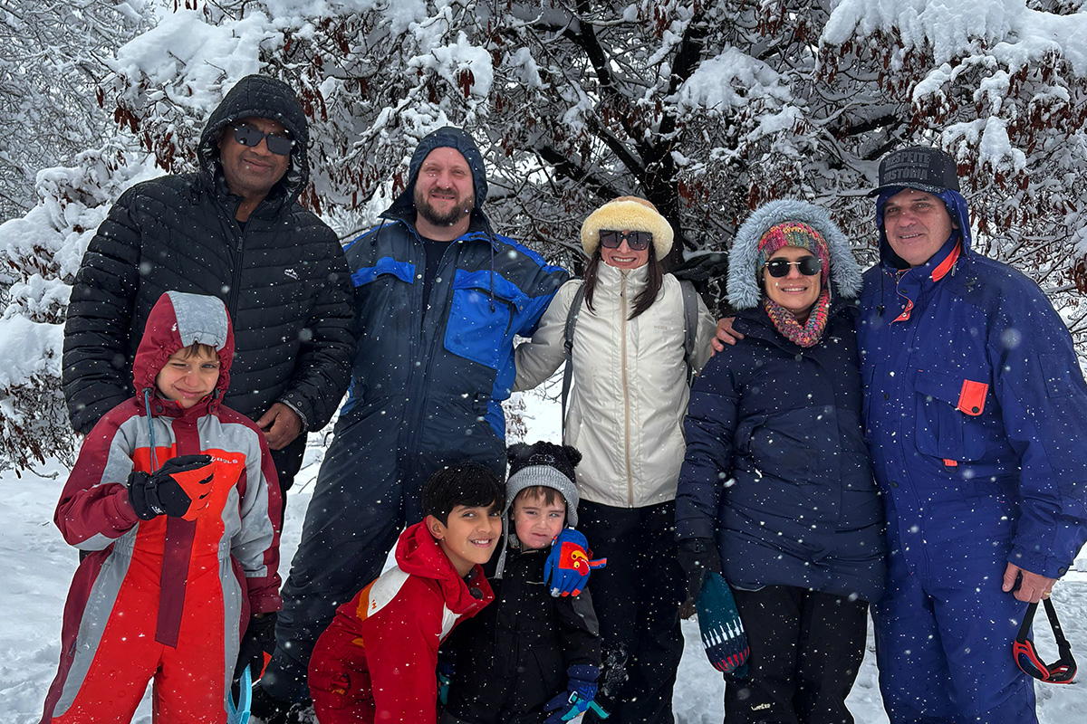 Grupo familiar en la nieve con bosque nevado de fondo