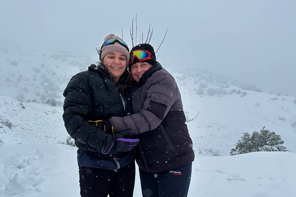 Madre e hija se abrazan en la nieve